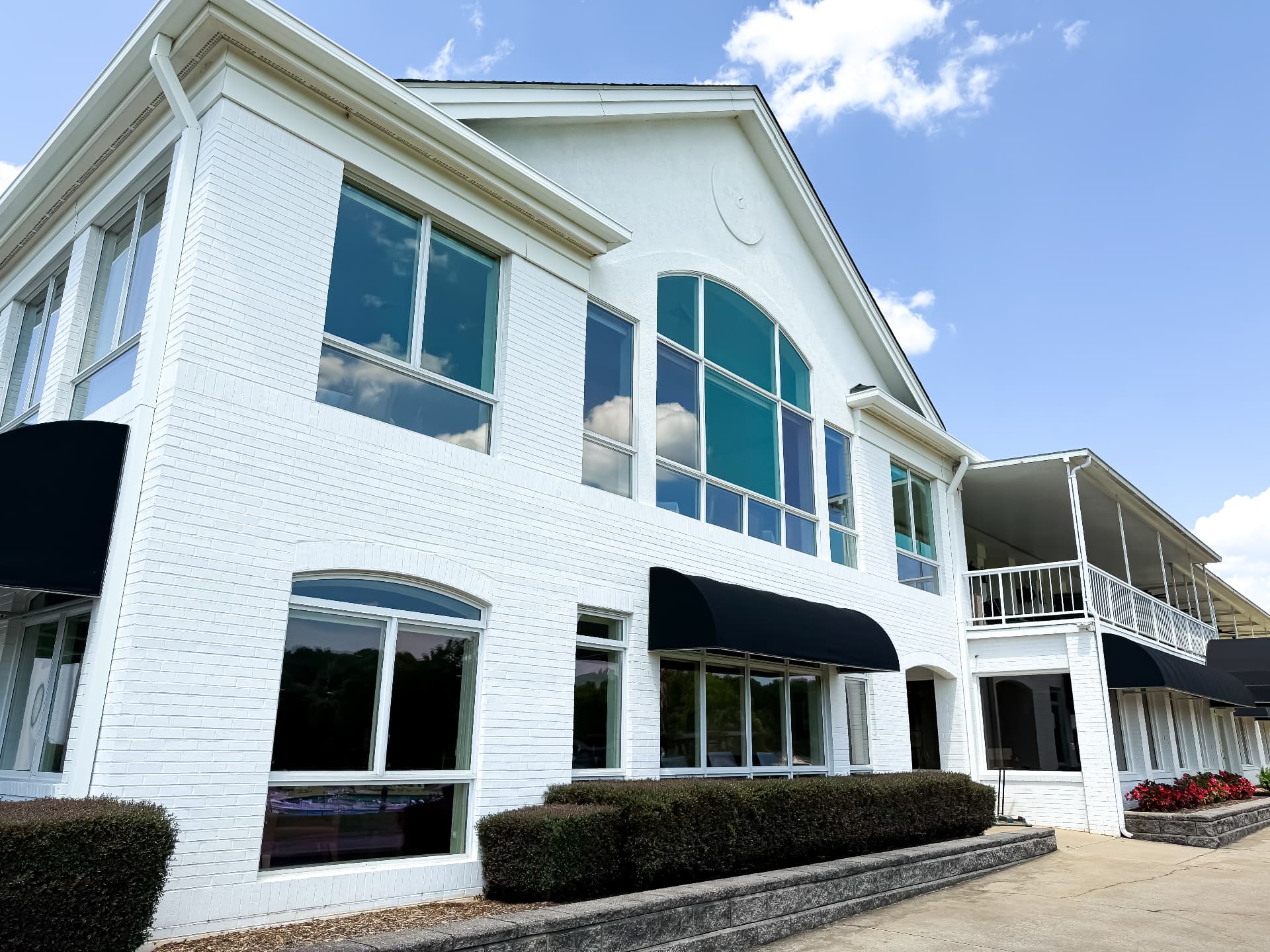 Large commercial property with white exterior and two-story windows