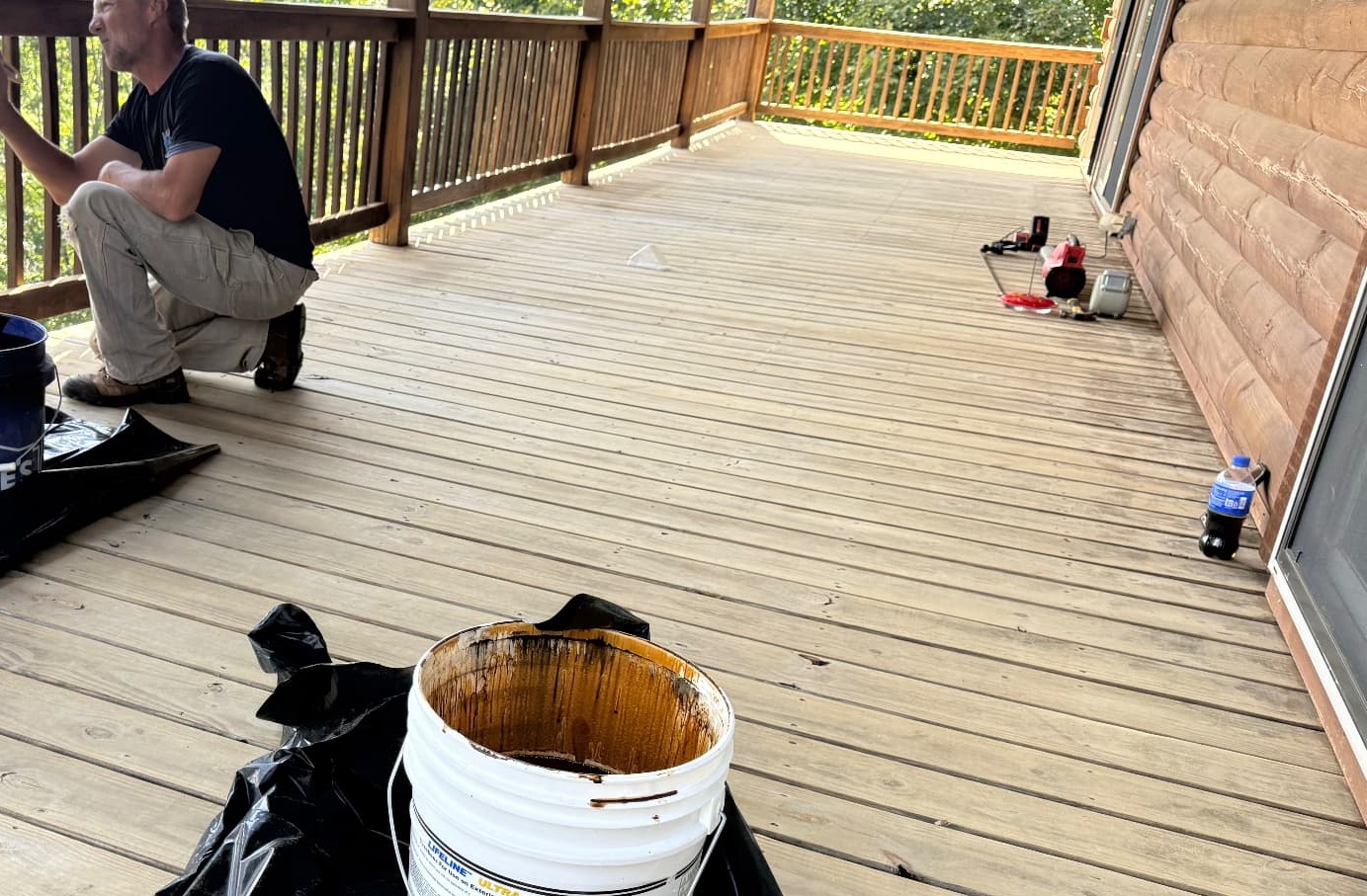 ProFlow crew applying stain to a deck railing